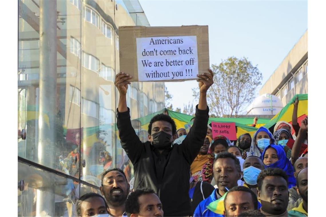Ein Protestteilnehmer mit einem Transparent, auf dem zu lesen ist „Amerikaner, kommt nicht zurück. Uns geht es besser ohne euch“. Foto: AP/dpa