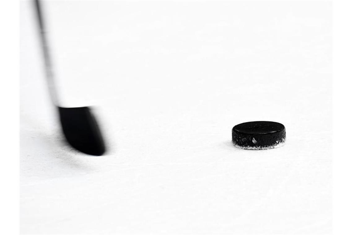 Veranstaltungsverbot: „neue Herausforderung“ für Adler Ein Puck und ein Eishockeyschläger. Foto: Tobias Hase/dpa/Archivbild