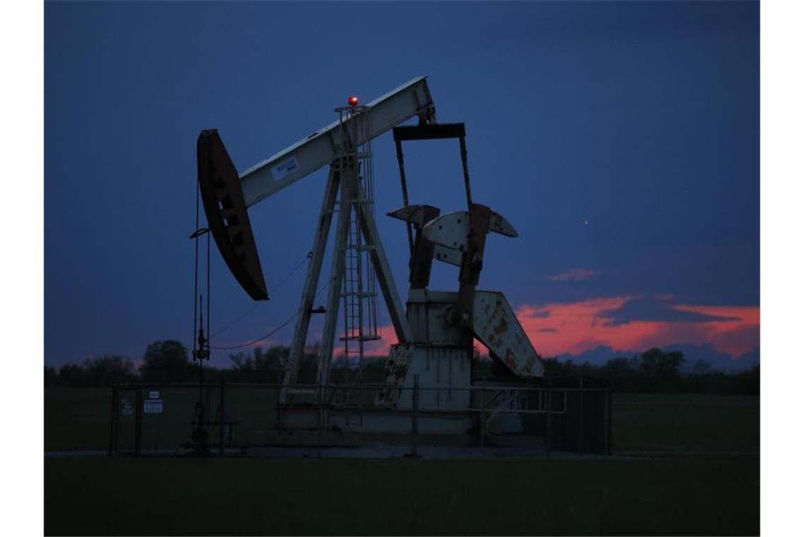 Ein Pumpe arbeitet bei Sonnenuntergang in einem Ölfeld. Der Höhenflug der Ölpreise hält an. Am Montagmorgen markierten die beiden wichtigsten Erdölsorten abermals mehrjährige Höchststände. Foto: Sue Ogrocki/AP/dpa