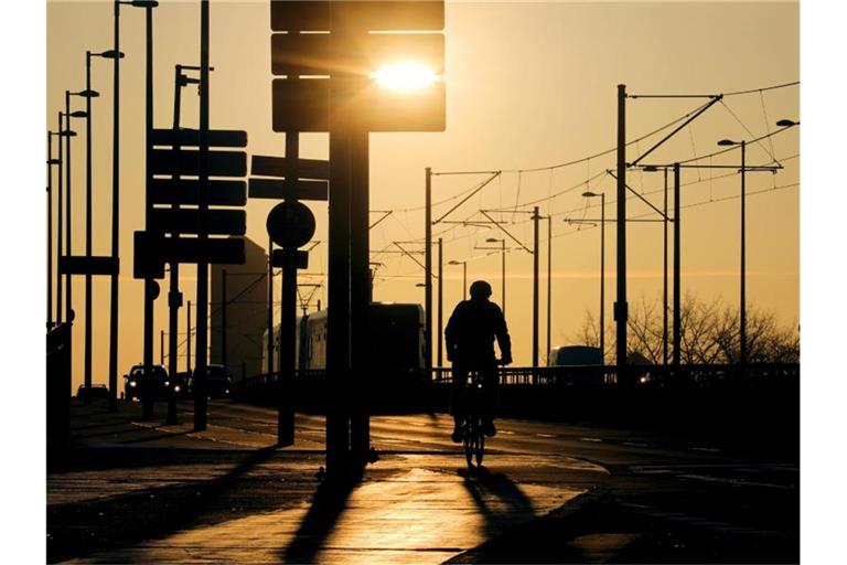 Ein Radfahrer fährt über die Deutzer Brücke in Köln. Die Zahl der Corona-Neuinfektionen steigt. Foto: Oliver Berg/dpa