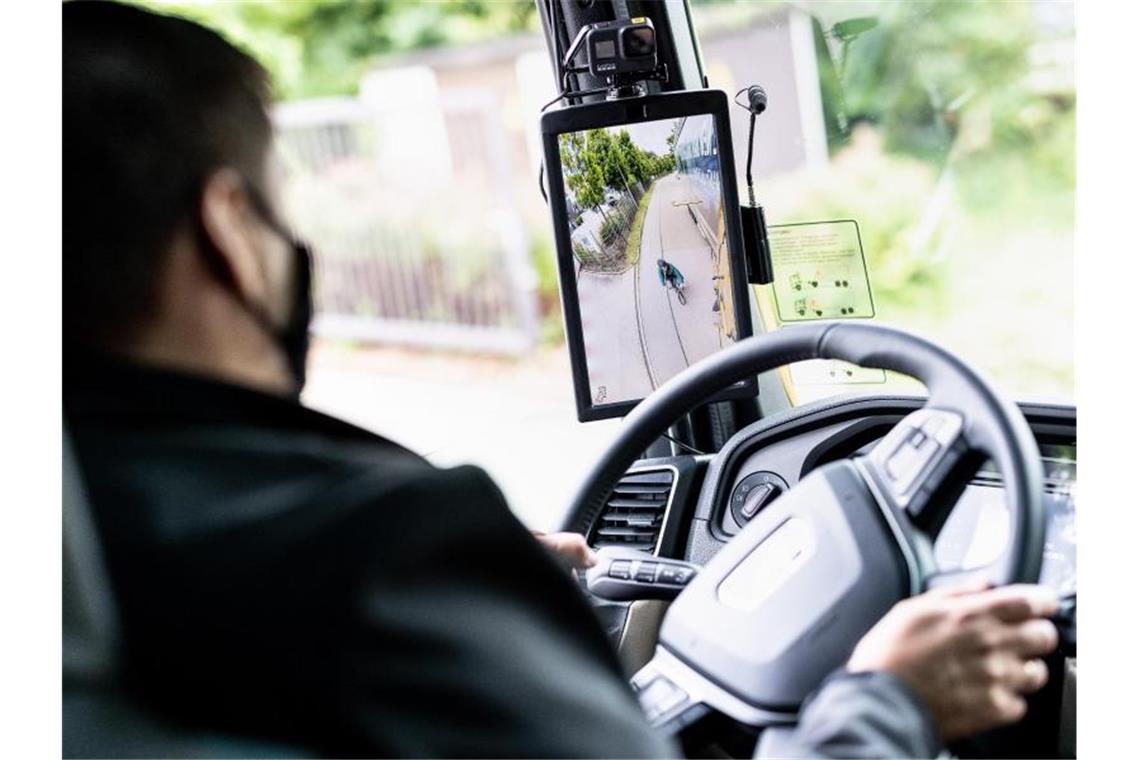 Ein Radfahrer ist bei einem Pressetermin zur Vorführung des digitalen Spiegelersatzsystems „MAN OptiView“ im digitalen Außenspiegel eines Lastwagens zu sehen. Foto: Matthias Balk/dpa