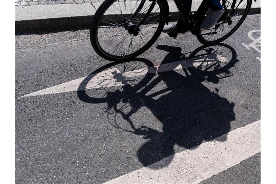 Ein Radfahrer wirft auf einem ausgewiesenen Radweg seinen Schatten. Foto: Peter Kneffel/Archivbild