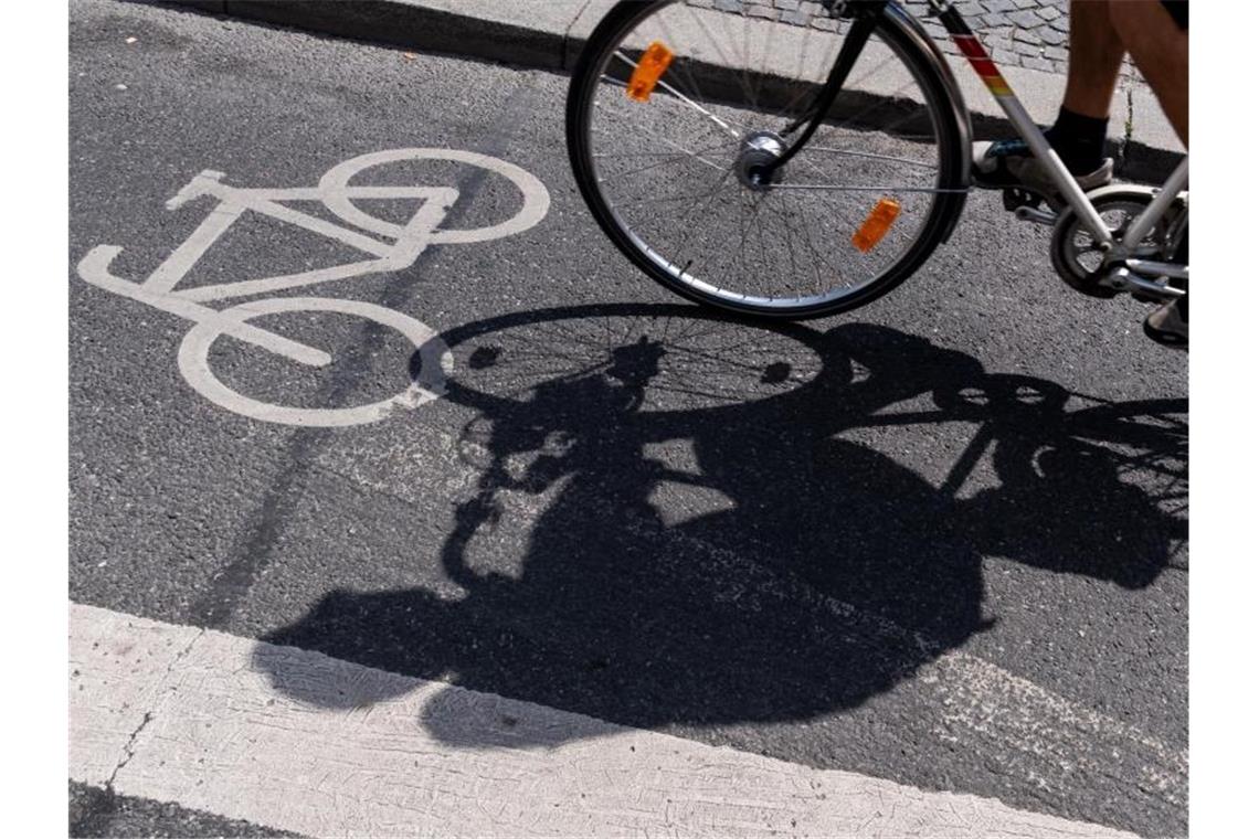 Ein Radfahrer wirft einen Schatten auf einem ausgewiesenen Radweg. Foto: Peter Kneffel/dpa/Symbolbild