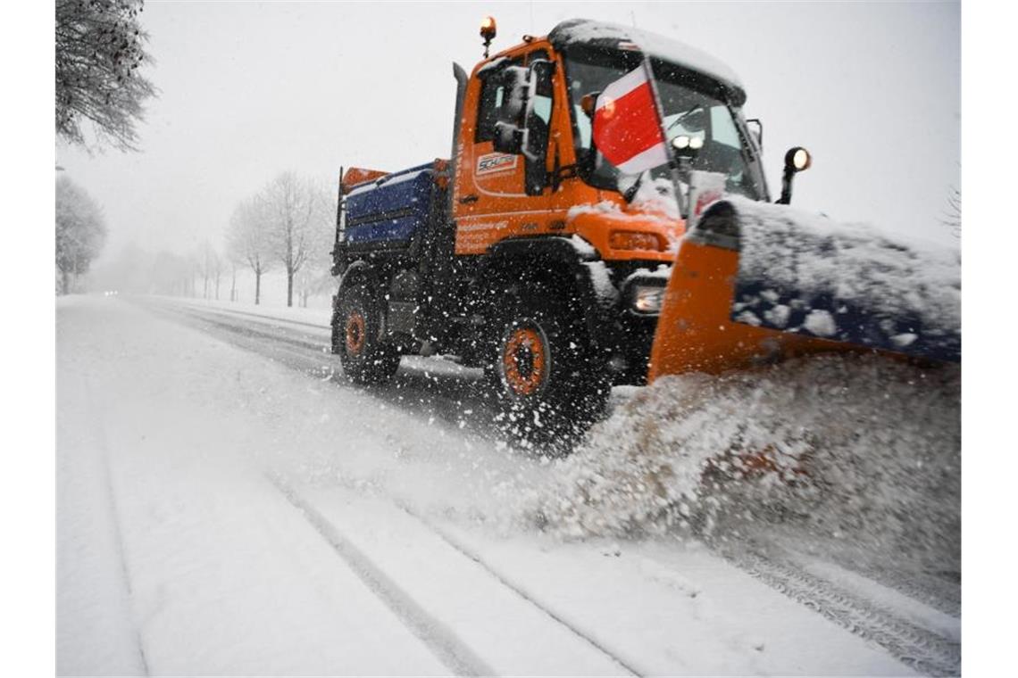 Ein Räumfahrzeug bahnt eine verschneite Straße frei. Foto: Felix Kästle/dpa/Archivbild