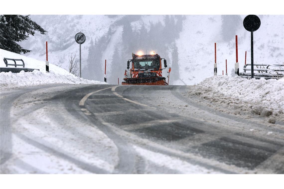 Ein Räumfahrzeug des Winterdienstes fährt auf dem Riedbergpass im Schneetreiben.