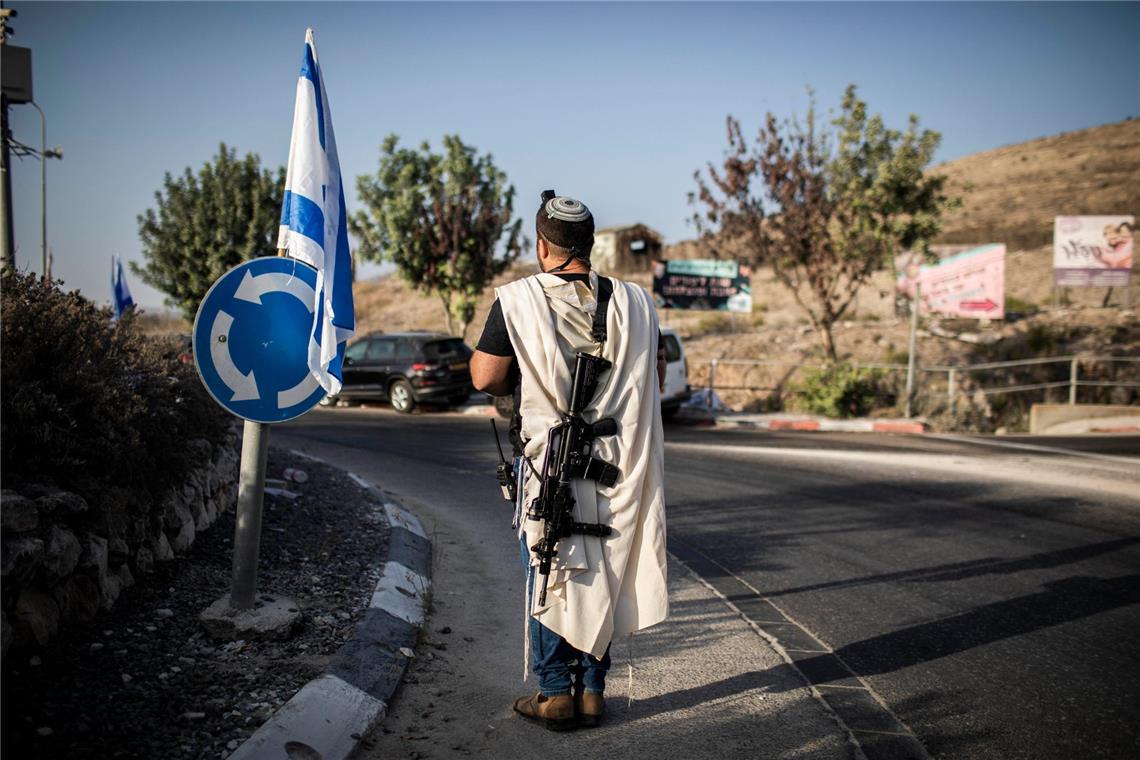 Israels Armee erklärt weitere Hamas-Geisel für tot Ein rechtsgerichteter israelischer Siedler trägt eine Waffe am Haupteingang der palästinensischen Stadt Nablus (Archivfoto).