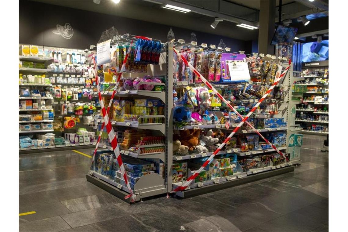 Ein Regal mit Spielzeug, also nicht-essentiellen Waren, ist in einem Genfer Supermarkt mit Flatterband abgesperrt. Foto: Salvatore Di Nolfi/KEYSTONE/dpa