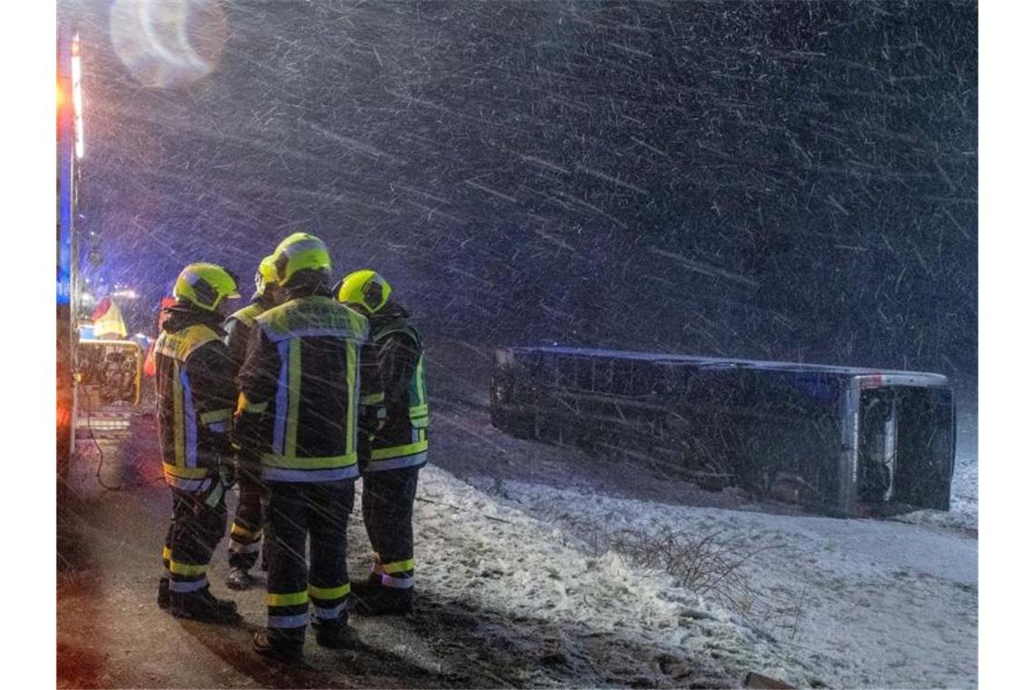 Sturm wütet über Südwesten: Verletzte bei Reisebus-Unfall Ein Reisebus liegt umgestürzt neben der B10 in einem Feld. Foto: Stefan Puchner/dpa