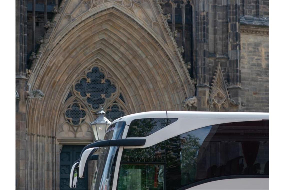 Auch 2021 Corona-Hilfe für Busreiseanbieter im Südwesten Ein Reisebus steht vor einer Kirche. Foto: Klaus-Dietmar Gabbert/dpa-Zentralbild/dpa/Symbolbild