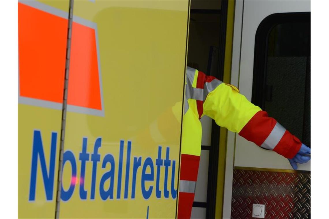 Ein Rettungsassistent steigt in einen Rettungswagen. Foto: Jens Kalaene/Archivbild