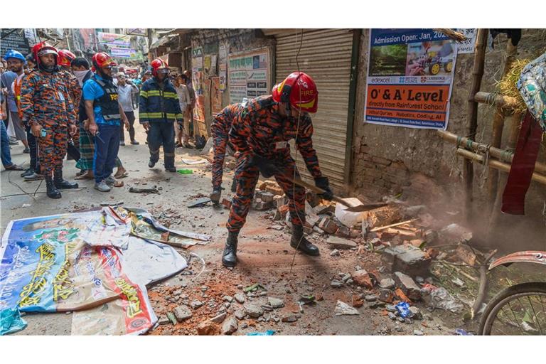 Ein Rettungsdienst-Mitarbeiter räumt nach einem Erdbeben die Trümmer von eingestürzten Gebäudeteilen weg.