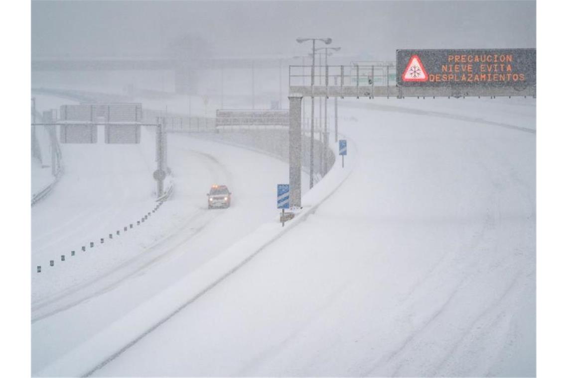 Ein Rettungsfahrzeug fährt auf der leeren, schneebedeckten Schnellstraße M-30 durch Madrid. Foto: Meng Dingbo/XinHua/dpa