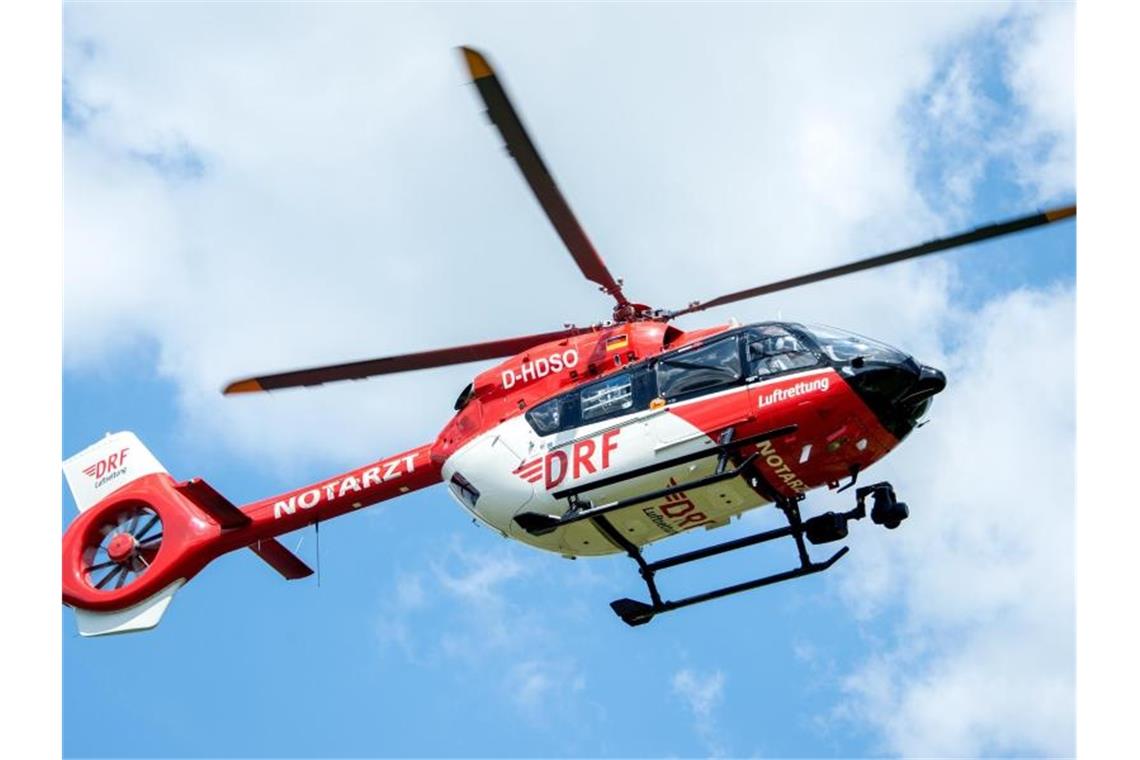 Ein Rettungshelikopter fliegt vor weißen Wolken. Foto: Hauke-Christian Dittrich/dpa/Symbolbild