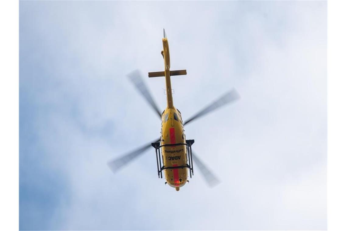 Winzer von Traktor überrollt und lebensgefährlich verletzt Ein Rettungshubschraube fliegt vor bewölktem Himmel. Foto: Sebastian Gollnow/Archivbild