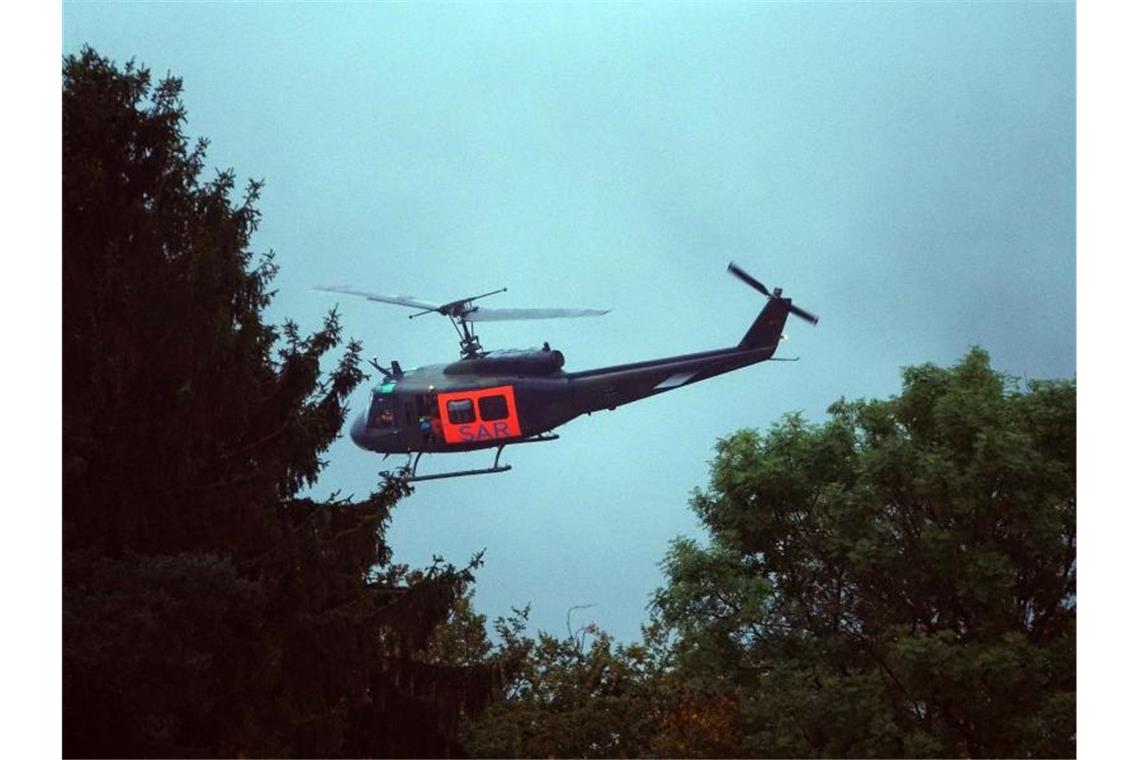 Ein Rettungshubschrauber des Militärs fliegt über dem Absturzgebiet in Zemmer-Rodt. Foto: Harald Tittel/dpa