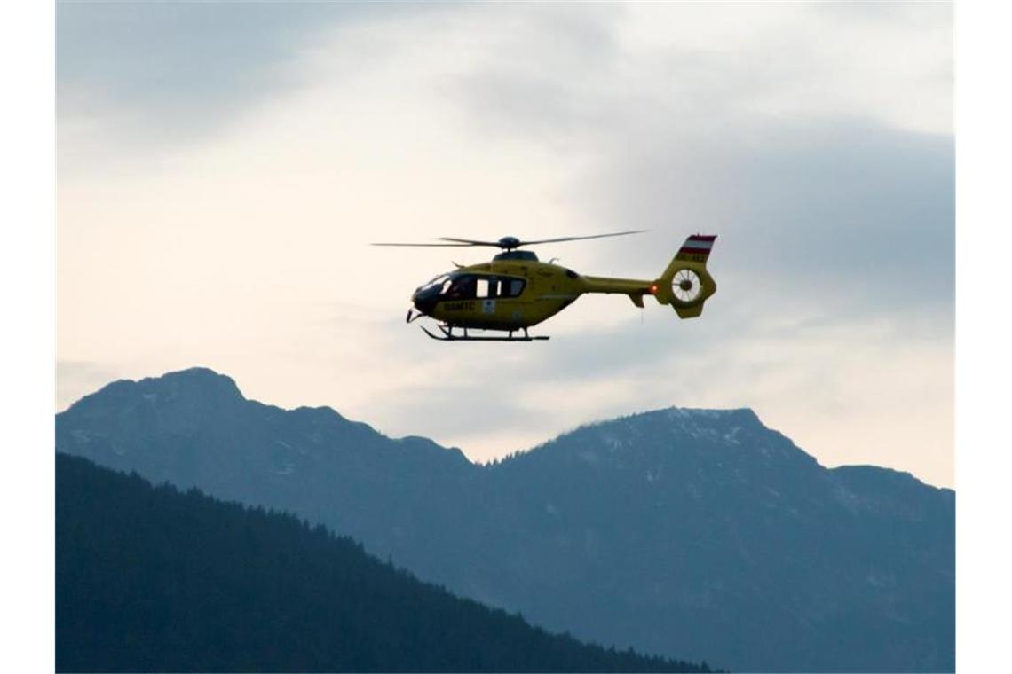 Ein Rettungshubschrauber fliegt über die Alpen. Foto: -/BRK BGL/dpa/Symbolbild