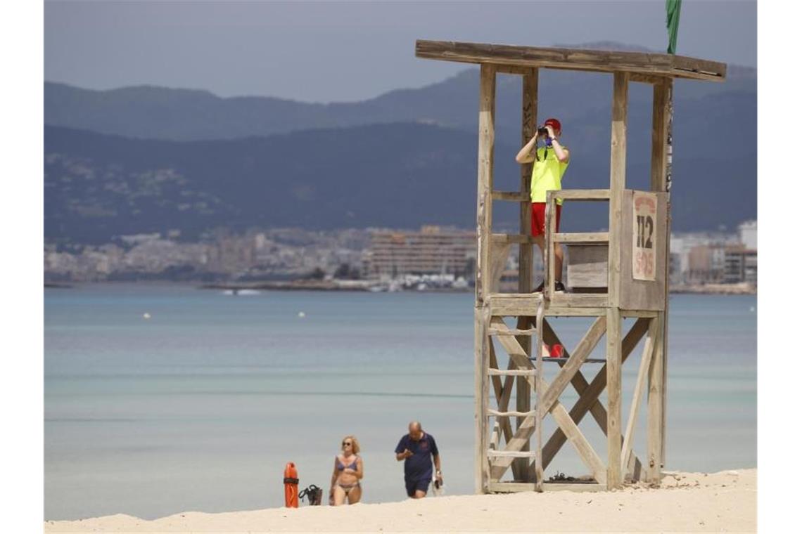 Ein Rettungsschwimmer beobachtet den Strand von El Arenal auf Mallorca. Foto: Clara Margais/dpa