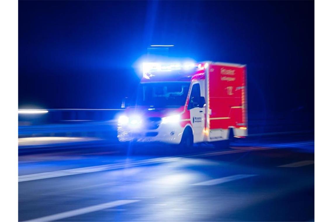 Ein Rettungswagen der Feuerwehr fährt mit Blaulicht durch eine Straße. Foto: Marcel Kusch/dpa/Illustration