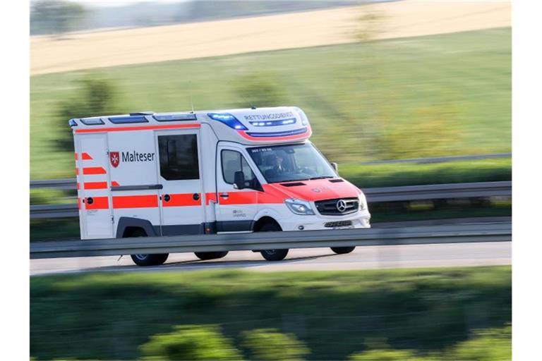 Ein Rettungswagen der Malteser fährt mit Blaulicht von der Unfallstelle. Foto: Jan Woitas/zb/dpa/Archivbild