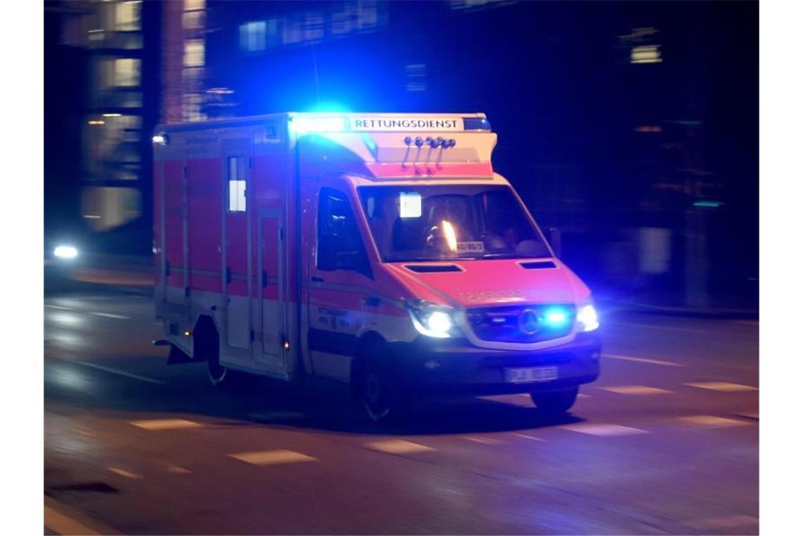 Ein Rettungswagen fährt abends mit Blaulicht über die beleuchtete Straße. Foto: Carsten Rehder/Archivbild