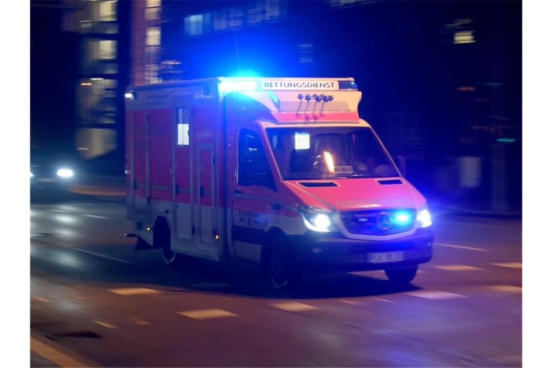 Ein Rettungswagen fährt abends mit Blaulicht über die beleuchtete Straße. Foto: Carsten Rehder/dpa/Archivbild