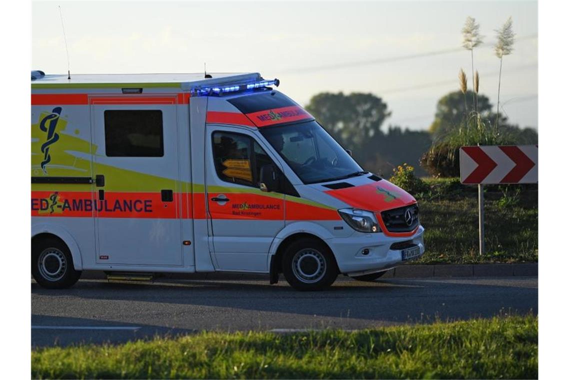 84-Jähriger kracht mit seinem Wagen in Auto und Hauswand Ein Rettungswagen fährt mit Blaulicht durch einen Kreisverkehr. Foto: Patrick Seeger/dpa