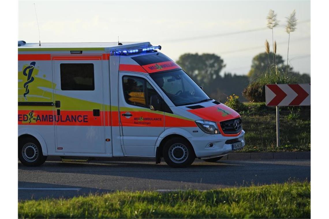 Ein Rettungswagen fährt mit Blaulicht durch einen Kreisverkehr. Foto: Patrick Seeger/dpa