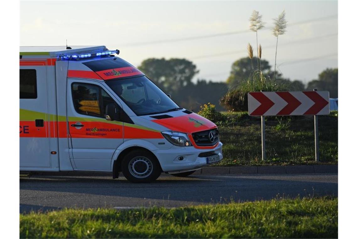 Eine Verletzte nach Frontalzusammenstoß bei Kirchheim Ein Rettungswagen fährt mit Sondersignal durch einen Kreisverkehr. Foto: Patrick Seeger/dpa/Archivbild