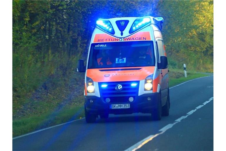 Ein Rettungswagen fährt während eines Einsatzes über eine Landstraße. Foto: Jens Wolf/Archivbild