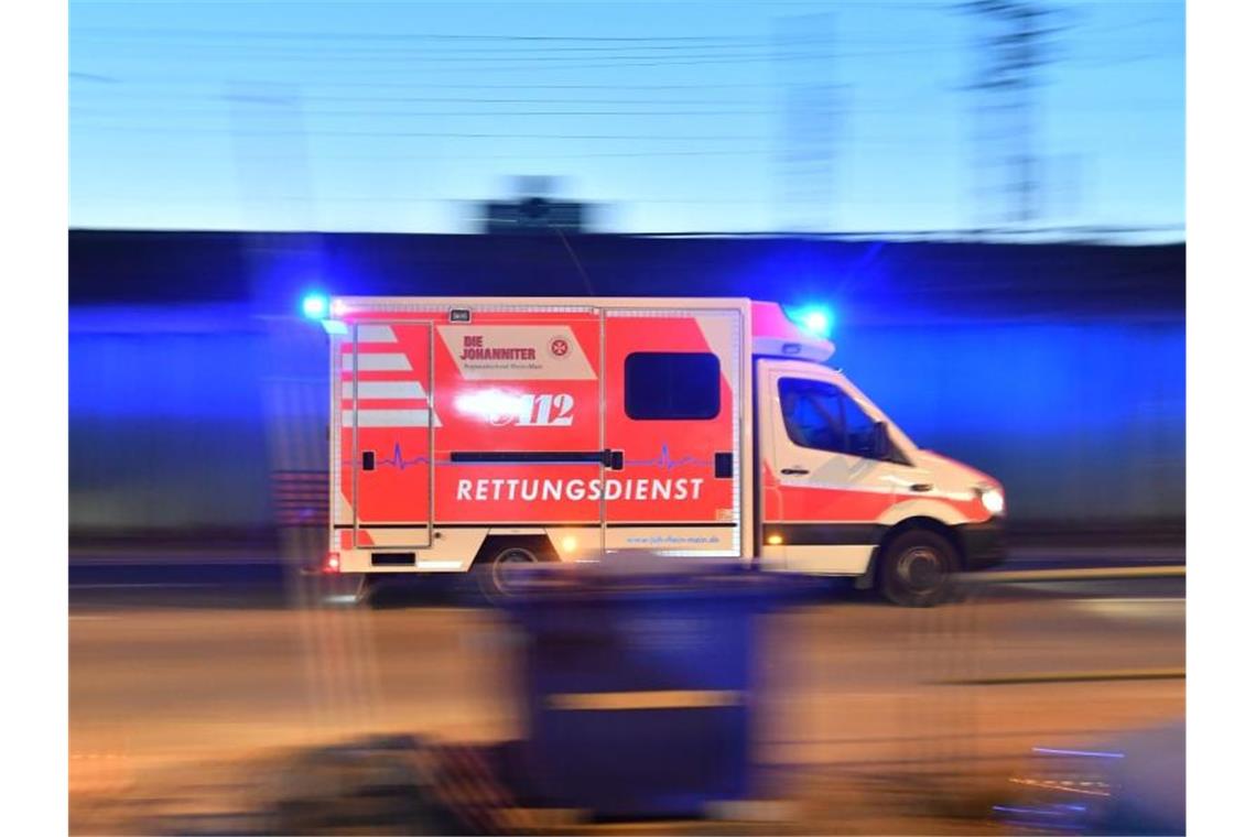Ein Rettungswagen ist mit eingeschaltetem Blaulicht im Einsatz. Foto: Boris Roessler/dpa/Archivbild