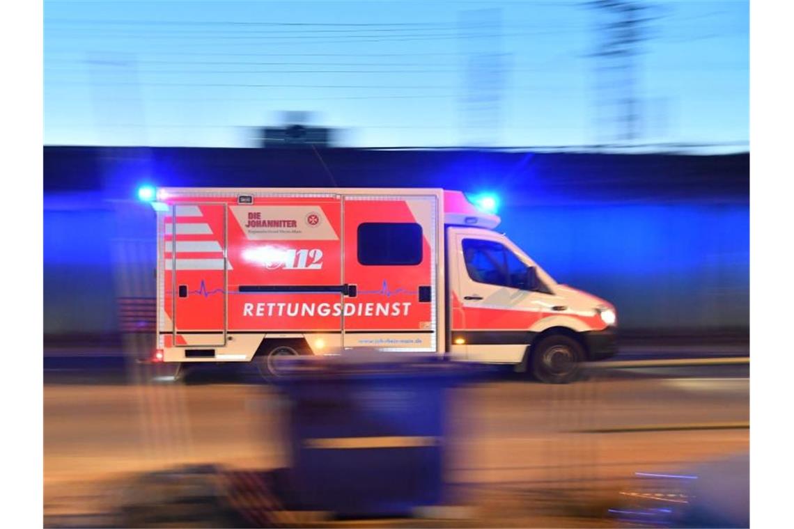 Ein Rettungswagen ist mit eingeschaltetem Blaulicht im Einsatz. Foto: Boris Roessler/dpa/Archivbild