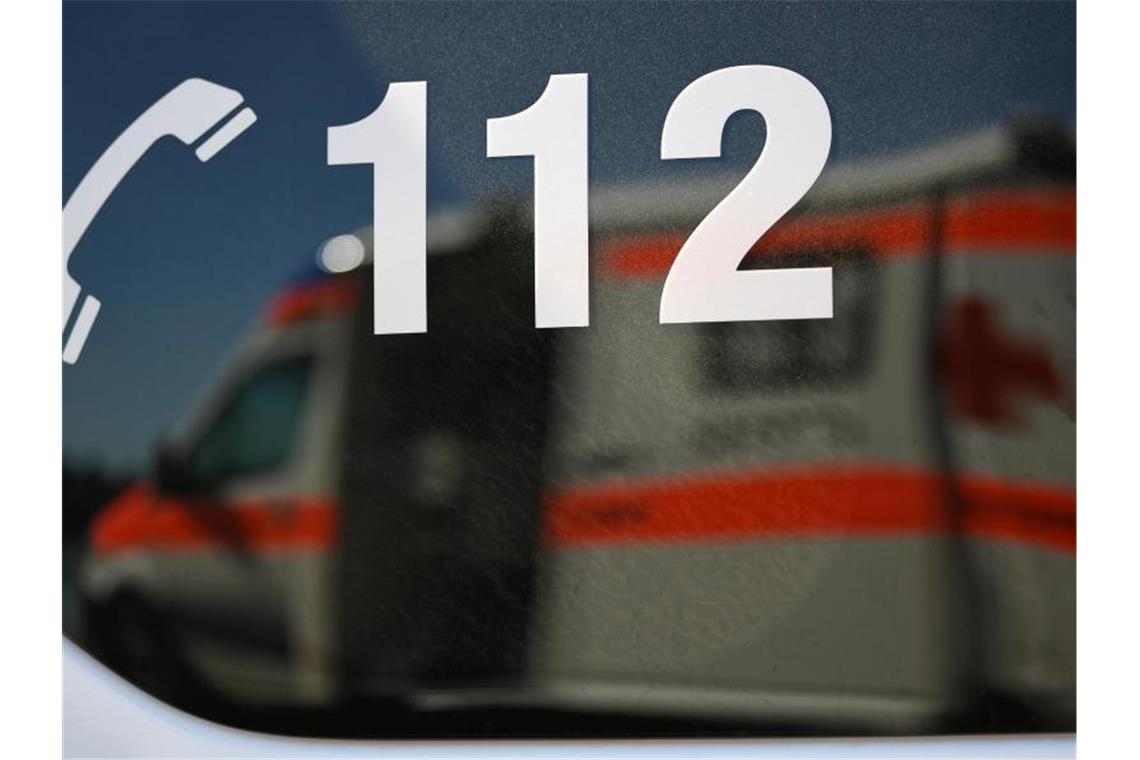 Ein Rettungswagen spiegelt sich während einer Übung in einem Fenster eines anderen Rettungswagen mit der Aufschrift „112“. Foto: Patrick Seeger/dpa