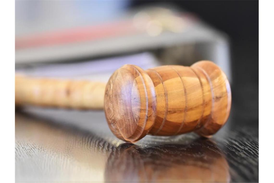 Ein Richterhammer aus Holz auf einer Richterbank. Foto: Uli Deck/dpa/Symbolbild