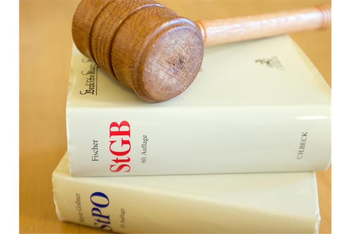 Ein Richterhammer und ein Strafgesetzbuch liegen auf einem Tisch. Foto: picture alliance / dpa