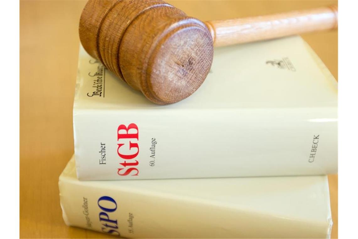 Ein Richterhammer und ein Strafgesetzbuch liegen auf einem Tisch. Foto: picture alliance / dpa / Archivbild