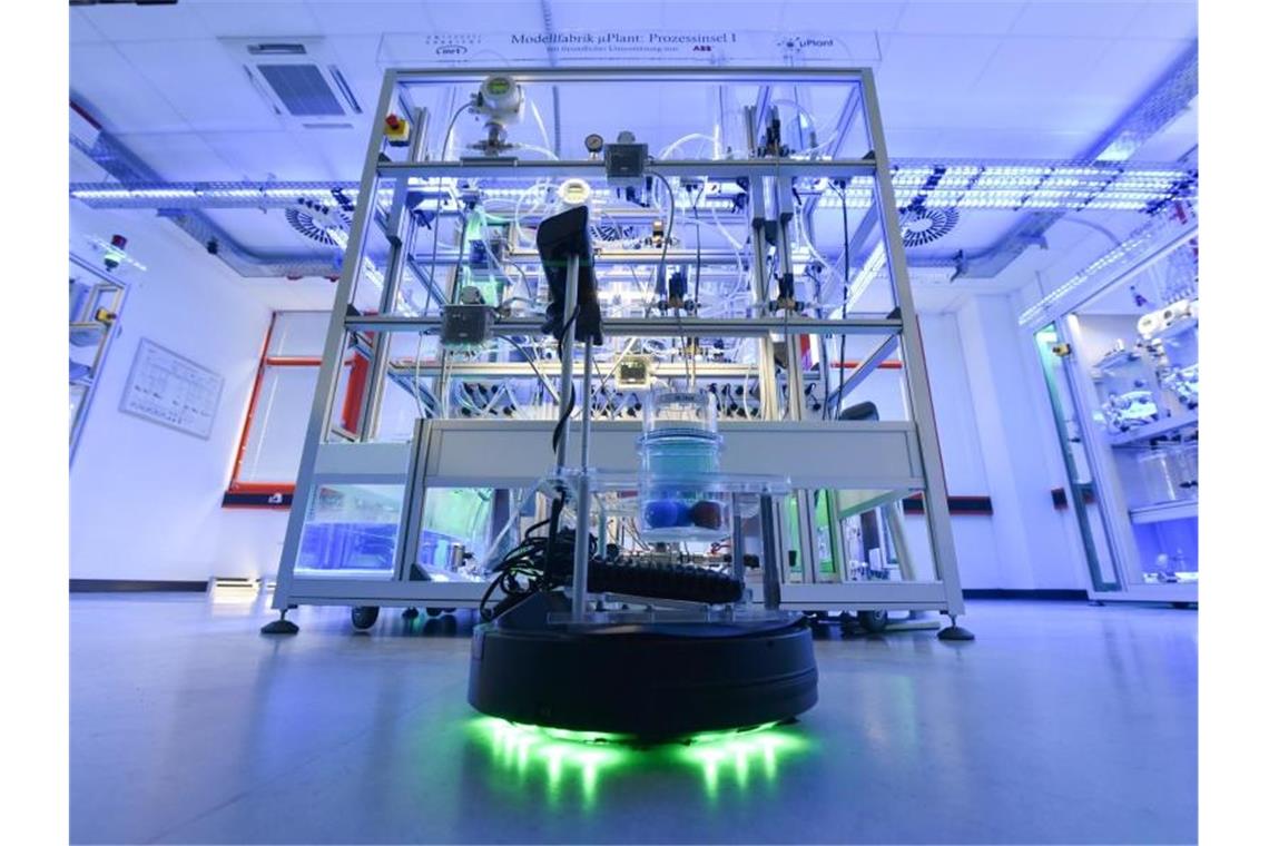 Ein Roboter fährt bei der Vorstellung einer vollautomatisierten Modellfabrik an der Universität Kassel durch den Raum. Foto: picture alliance / Uwe Zucchi/dpa
