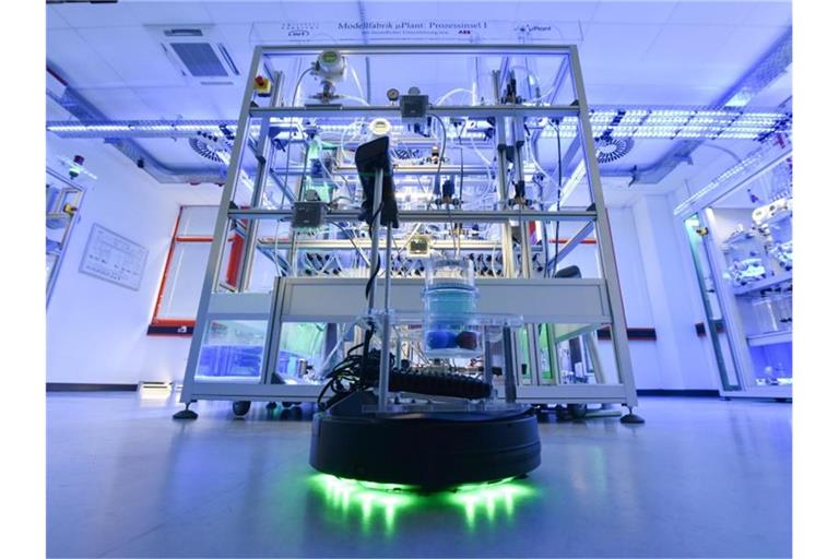 Ein Roboter fährt bei der Vorstellung einer vollautomatisierten Modellfabrik an der Universität Kassel durch den Raum. Foto: picture alliance / Uwe Zucchi/dpa