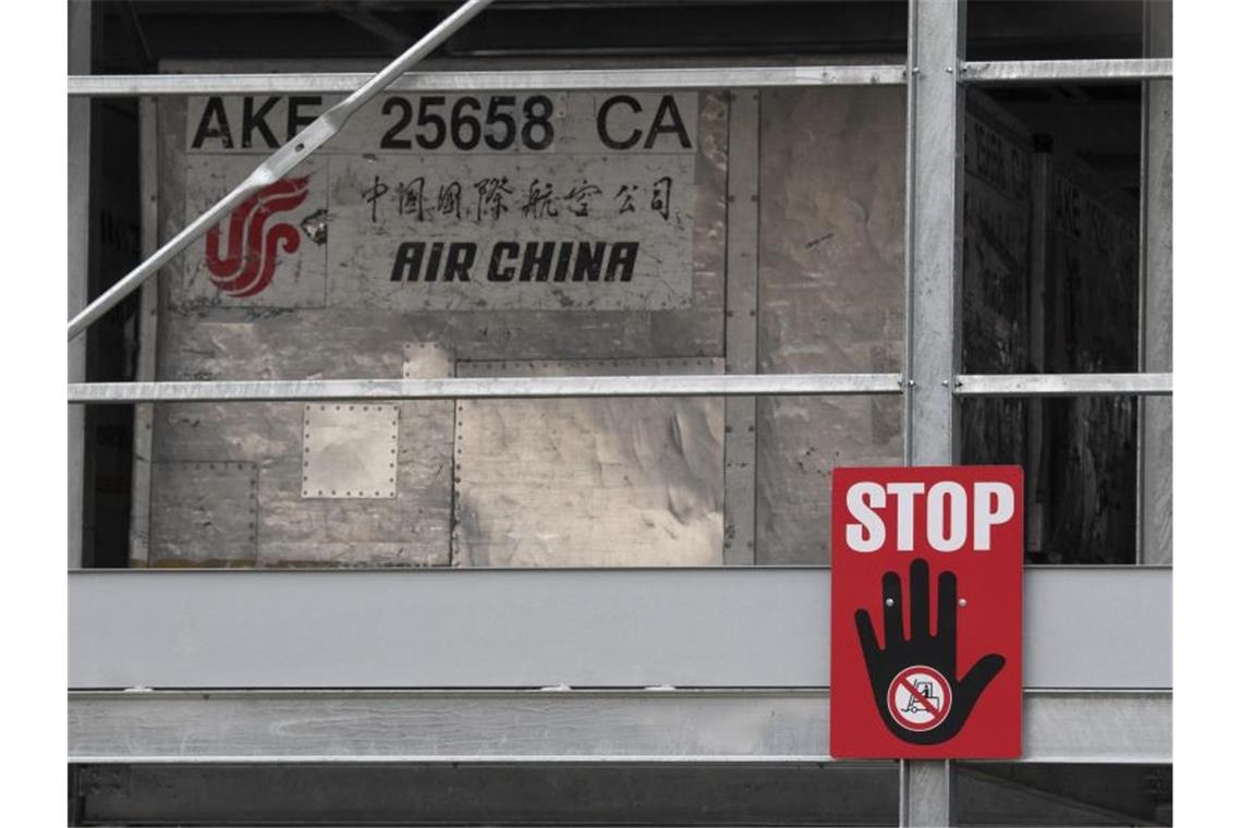 Ein rotes Warnschild mit der Aufschrift „Stop“ hängt an einem Lager für leere Frachtcontainer im Cargo-Bereich des Flughafens Frankfurt. (Archivbild). Foto: Boris Roessler/dpa