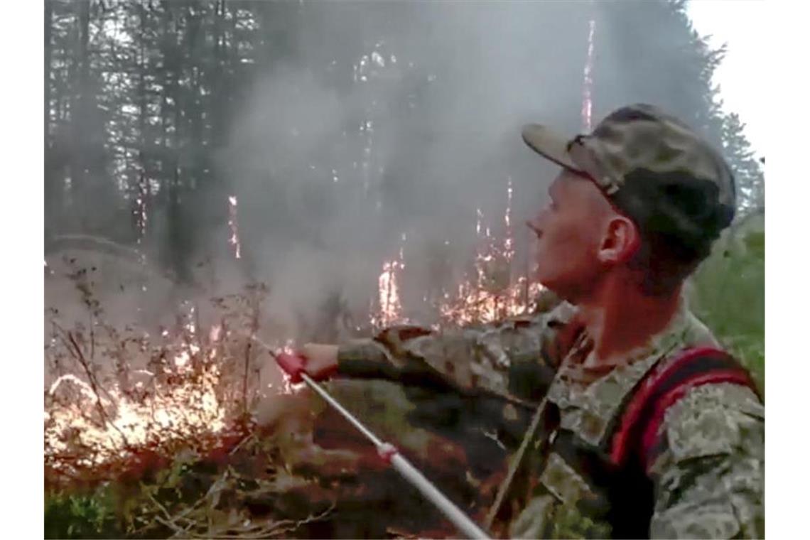 Waldbrandkatastrophe in Russland weitet sich aus Ein russischer Militäringenieur des Militärbezirks Ost versucht einen Brand in der Republik Sacha (Jakutien) zu löschen. Foto: --/Russian Defense Ministry Press Service/AP/dpa