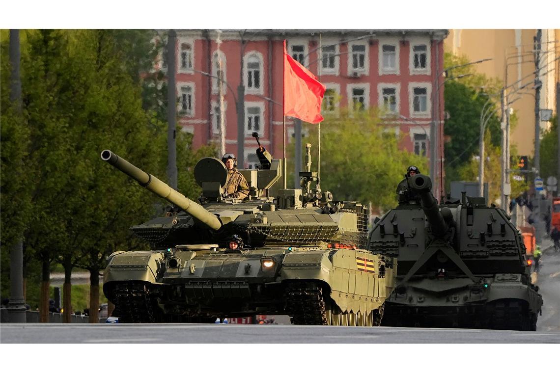 Ein russischer Panzer und eine Panzerhaubitze rollen auf einer Straße in Richtung Roter Platz, um an einer Probe für die Militärparade zum Tag des Sieges  teilzunehmen.