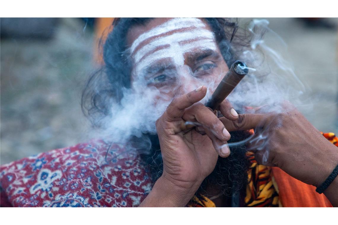Ein Sadhu raucht während der jährlichen Pilgerreise zu den Amarnath-Höhlen, einem der heiligsten Orte des Hinduismus, in Pahalgam  im indischen Unionsterritorium Jammu und Kaschmir.