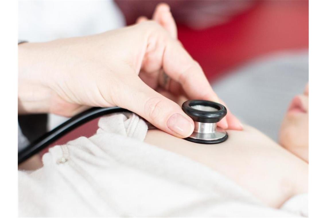 Welle von Virus-Infektionen bei kleinen Kindern in Kliniken Ein Säugling wird von einem Kinderarzt mit einem Stethoskop abgehört. Foto: Friso Gentsch/dpa/Symbolbild