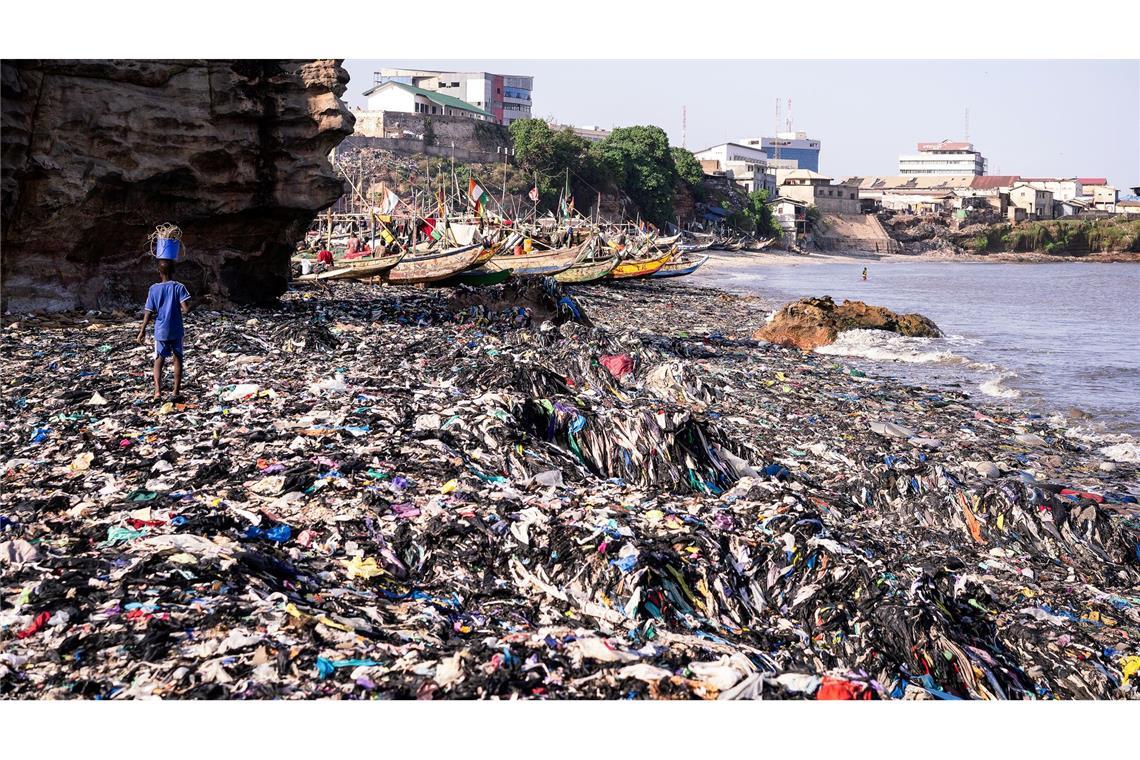 Ein Sandstrand, dessen Sand gar nicht mehr zu sehen ist: Massen an Klamotten vermüllen diesen Küstenabschnitt von Accra.