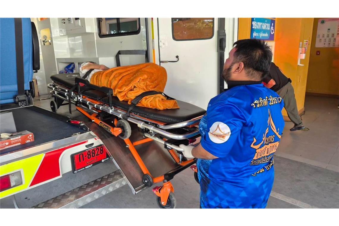 Ein Sanitäter transportiert eine ältere Frau, die noch am Leben war, nachdem sie als verstorben galt, vor ihrer geplanten Einäscherung im Tempel Wat Rat Prakhong Tham in der thailändischen Provinz Nonthaburi in ein örtliches Krankenhaus.