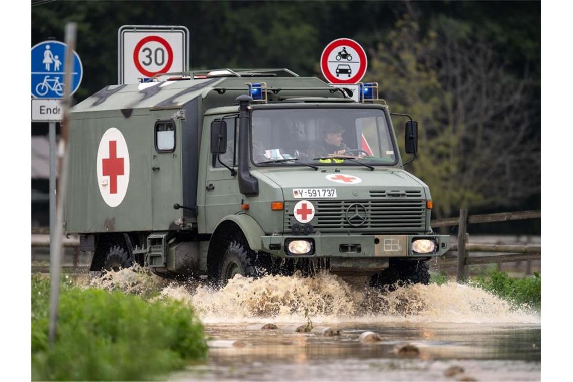 Flutkatastrophe: Mehr als 100 Tote - Lage bleibt angespannt Ein Sanitätsfahrzeug der Bundeswehr fährt über eine überflutete Straße. Foto: Marius Becker/dpa