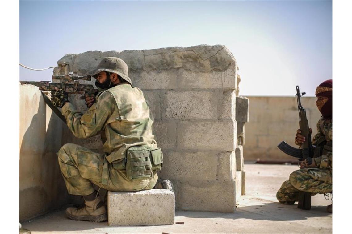 Trump kündigt Sanktionen gegen Türkei an Ein Scharfschütze der mit der Türkei verbündeten Syrischen Nationalarmee zielt mit einer Waffe von einem Dach in Tall Abjad. Foto: Anas Alkharboutli/dpa