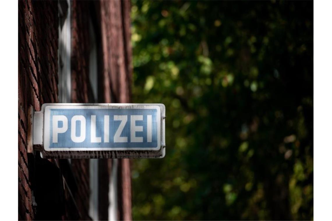 Mann wirft Stein und bespuckt Polizisten Ein Schild, auf dem „Polizei“ steht, hängt an einer Wache. Foto: Fabian Strauch/dpa/Symbolbild