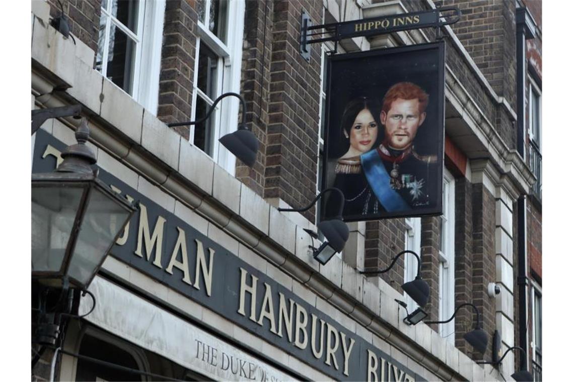 Bericht über Krisentreffen im Palast Ein Schild, das Prinz Harry und seine Frau Meghan zeigt, vor dem Pub "The Duke of Sussex" in London. Foto: Tony Hicks/AP/dpa