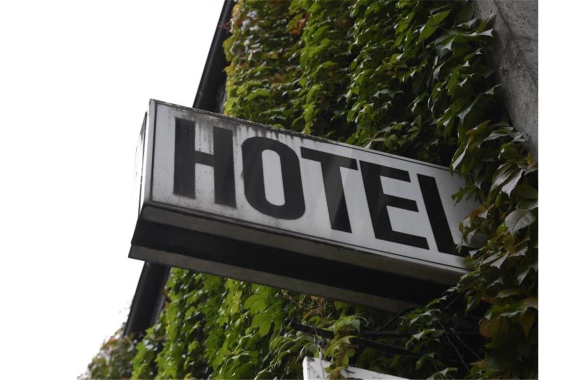 Ein Schild "Hotel" ist an der mit Efeu bewachsenden Wand eines Gebäudes angebracht. Foto: Roberto Pfeil/dpa/Archiv