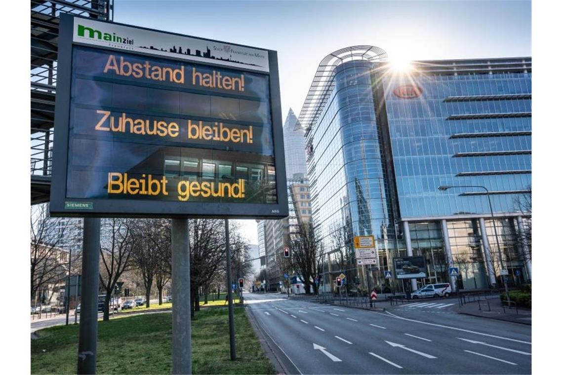 Corona-Ansteckungsrate in Deutschland deutlich gesunken Ein Schild in Frankfurt/Main: "Abstand halten! Zuhause bleiben! Bleibt gesund!". Foto: Frank Rumpenhorst/dpa
